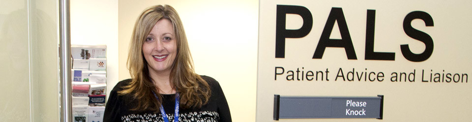 A picture of a woman stood outside the patient advice and liaison service room